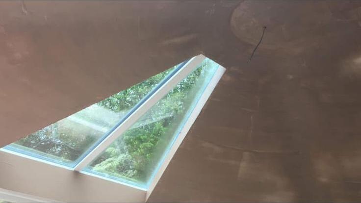 Smooth plastered vaulted ceiling finished neatly around a flush rooflight
